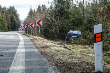 Bir araba trafik kazası sırasında yok. Araba durdurulmuş ve ağaçların karayoluyla standları. 
