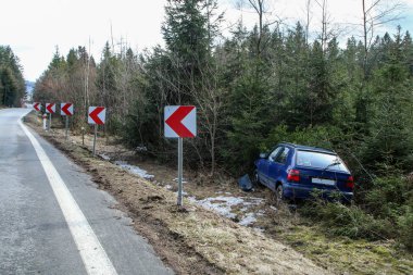 Bir araba trafik kazası sırasında yok. Araba durdurulmuş ve ağaçların karayoluyla standları. 