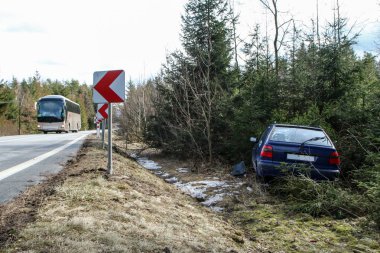 Bir araba trafik kazası sırasında yok. Araba durdurulmuş ve ağaçların karayoluyla standları. 