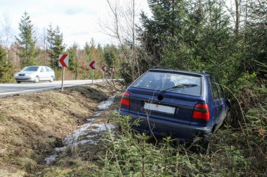Bir araba trafik kazası sırasında yok. Araba durdurulmuş ve ağaçların karayoluyla standları. 