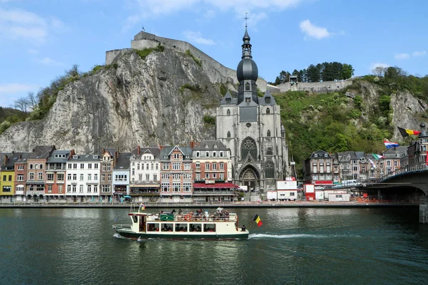 Güzel yaz günü boyunca tarihi Belçika kenti Dinant. Turistler nehirde bir teknede yüzüyor.. 