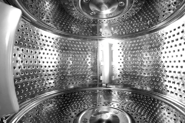 A look inside the perforated steel drum of the empty washing machine.
