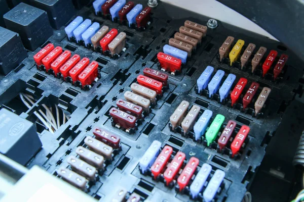 The detail of the fuse box in the cars engine room. Many fuses with different values of current.