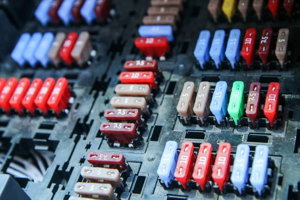 The detail of the fuse box in the cars engine room. Many fuses with different values of current.