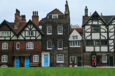 Mavi kapı ve bunlardan birinin önünde bir Beefeater Guard ile birkaç eski kırsal İngiliz evlerin bir resim. 