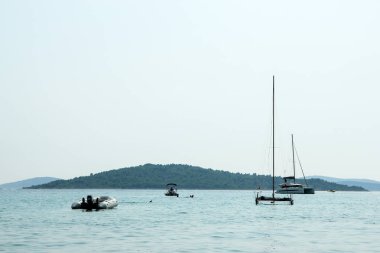 Birkaç tekneler sırasında sıcak yaz günü mavi okyanusta yüzen bir resim. İnsanlar için rahatlatıcı tatil etkinlik. 