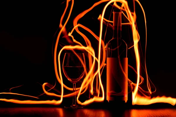 Παίζοντας Ίχνη Της Φωτιάς Γύρω Από Ποτήρι Και Μπουκάλι Κρασιού — Φωτογραφία Αρχείου
