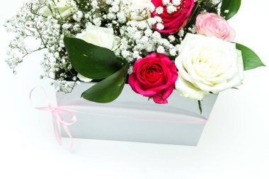 Beyaz bir arka plan üzerinde izole beyaz bir hediye kutusu düzenlenmiş güzel güller. Çiçeklerin çok güzel ve romantik bir görünüm. 