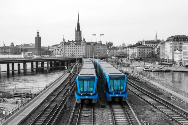 ストックホルムの伝統的な近代的なスウェーデンの地下鉄の列車は 旧市街の中心から橋の上を運転しています 列車は白黒の背景で隔離されている — ストック写真