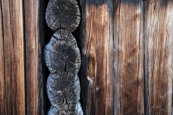 A detail of the planks of the scandinavian wooden house. The color of the house is old and looks shabby.