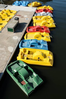 Birkaç boş renkli kürek tekneler nehir kenarında iskele tarafından su üzerinde duran. Turistler için eğlence.