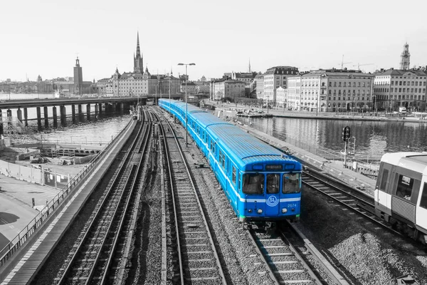 ストックホルムの伝統的な古いスウェーデンの地下鉄の列車は 旧市街の中心から橋の上を運転しています 列車は白黒の背景で隔離されている — ストック写真