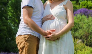 Hamile kadın ve partneri poz veriyor. Annelik, aile, ilgi ve sevgi sembolü.