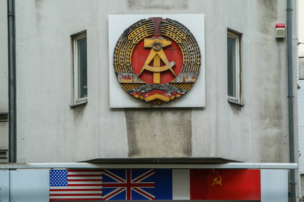The detail of the sign of the German democratic republic on one of the houses at Check point Charlie in Berlin.