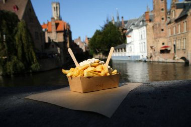 Geleneksel sokak yemekleri, Belçika 'nın Bruges şehrinde duvarda biber soslu Belçika kızartması resmi..
