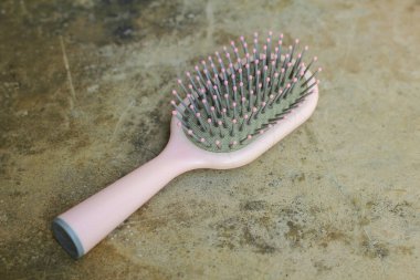 Kadının tarağı çimento zeminde izole edilmiş.