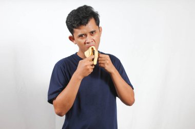 Muz yiyen genç Asyalı adam izole edilmiş beyaz arka plan