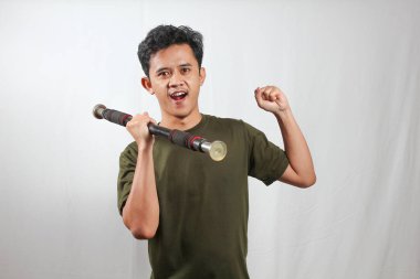 Asyalı adam beyaz arka planda izole edilmiş pazı kaslarını gösterirken hafif halteri kaldırıyor.