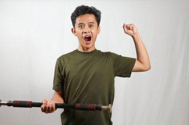 Heyecanlı Asyalı adam beyaz arka planda uzun halterleri kaldırıyor.