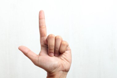 Etkileşimli kavramlar ve çarpışma ile görsel iletişim için mükemmel, temiz beyaz zemin üzerinde oyuncu bir silah şekli oluşturan etkileyici el hareketi