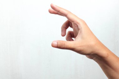 Beyaz arka planda izole edilmiş küçük bir nesneyi tutan adamın elini kapat