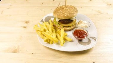Hamburger ve patates kızartması ahşap arka plan üzerinde
