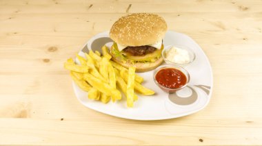 Hamburger ve patates kızartması ahşap arka plan üzerinde