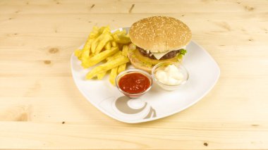Hamburger ve patates kızartması ahşap arka plan üzerinde