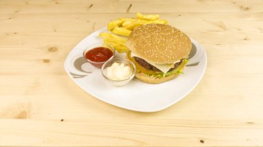 Hamburger ve patates kızartması ahşap arka plan üzerinde
