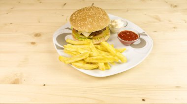Hamburger ve patates kızartması ahşap arka plan üzerinde