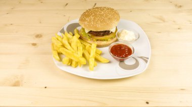 Hamburger ve patates kızartması ahşap arka plan üzerinde