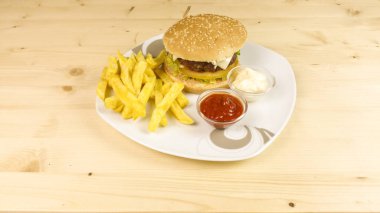 Hamburger ve patates kızartması ahşap arka plan üzerinde