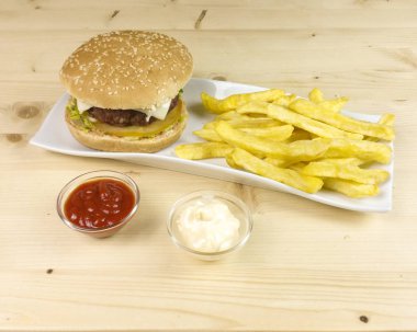 Hamburger ve patates kızartması ahşap arka plan üzerinde