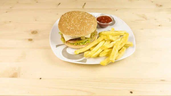 Burger and chips on wooden background