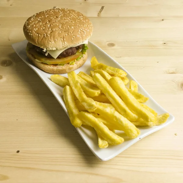 Hamburger ve patates kızartması ahşap arka plan üzerinde