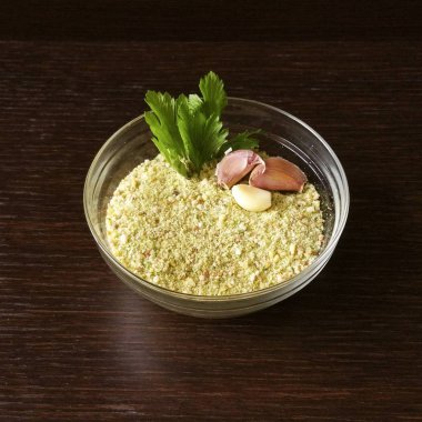 koyu ahşap zemin üzerine saydam bir kase galeta unu