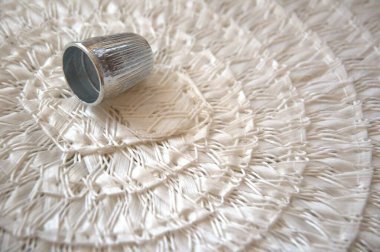 Kopya alanı ile dokuma arkaplan üzerinde tek gümüş yüksük.