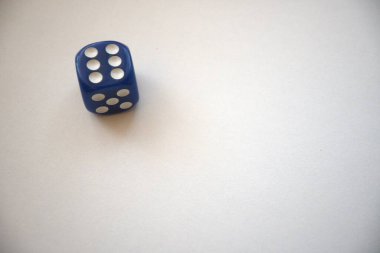 Bir mavi zar beyaz bir arkaplanda izole edilmiş altı nokta gösteriyor, kopyalama alanı ile yakın plan..