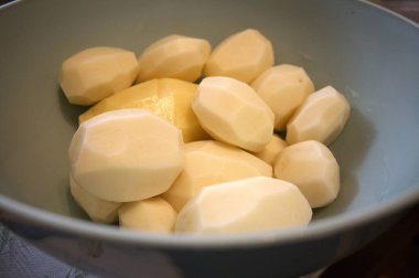 Mavi bir kasede çiğ patates, metin için fotokopi alanı ile yakın çekim..