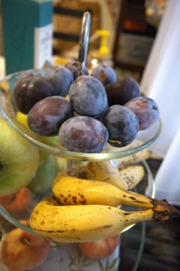 Şeffaf cam servis kâsesine yerleştirilmiş taze eriklerin yakın çekimi. Sağlıklı meyve kavramı.