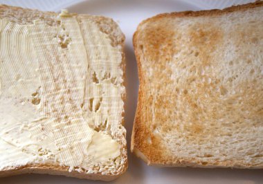 Bir tabakta iki dilim tost, biri margarinli ve biri sade, sembolik seçim, kahvaltı, diyet..