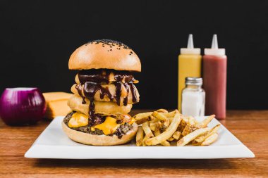 Doble burger doble çedar peyniri, marul, sosis, mantar ve patates kızartması ile