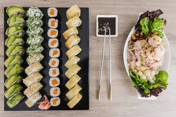 Suşi meze ve soya sosu ile ahşap bir masa üzerinde rulo