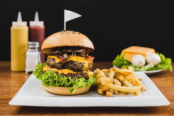 Doble burger doble çedar peyniri, marul, sosis, mantar ve patates kızartması ile