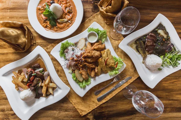 Comida peruana, ceviche, lomo saltado, piqueo en una elegante mesa de restaurante — Foto de Stock