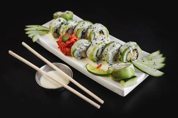 Siyah bir masada içindeki Ceviche sos ile avokado ve peynir suşi rulo