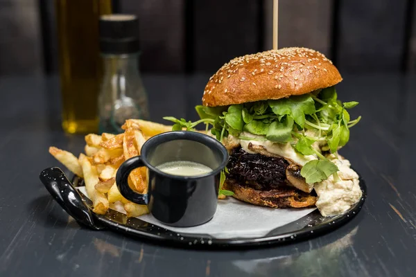 Ahşap masada sebze, sarımsak sosu ve patates kızartması ile cheeseburger