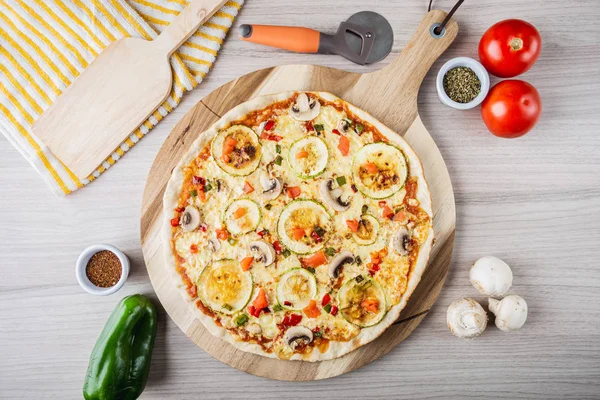 Zucchini vegan pizza with mushrooms, tomatoes, pepper and oregano