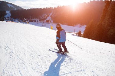 Genç adam, bir kayak merkezi dağlarda kayak