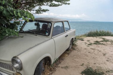 Terk edilmiş eski model Avrupa araba deniz kıyısında